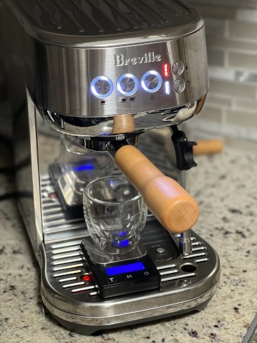 Breville Bambino espresso machine with a bottomless portafilter and a scale